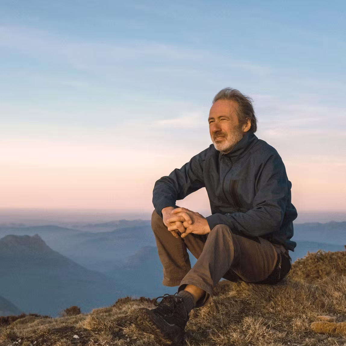 Man mediteert bij zonsondergang